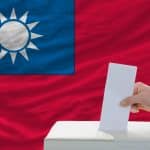 man voting on elections in taiwan front of flag