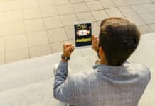 How to Increase Your Chances of Hitting the Jackpot in Online Casinos Back view man getting jackpot on mobile app on tablet, playing slots online