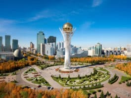 Investing in Kazakhstan’s Agriculture: Seizing New Opportunities Baiterek Tower in Astana, Kazakhstan, rises over a vibrant cityscape with modern skyscrapers and colorful autumn trees
